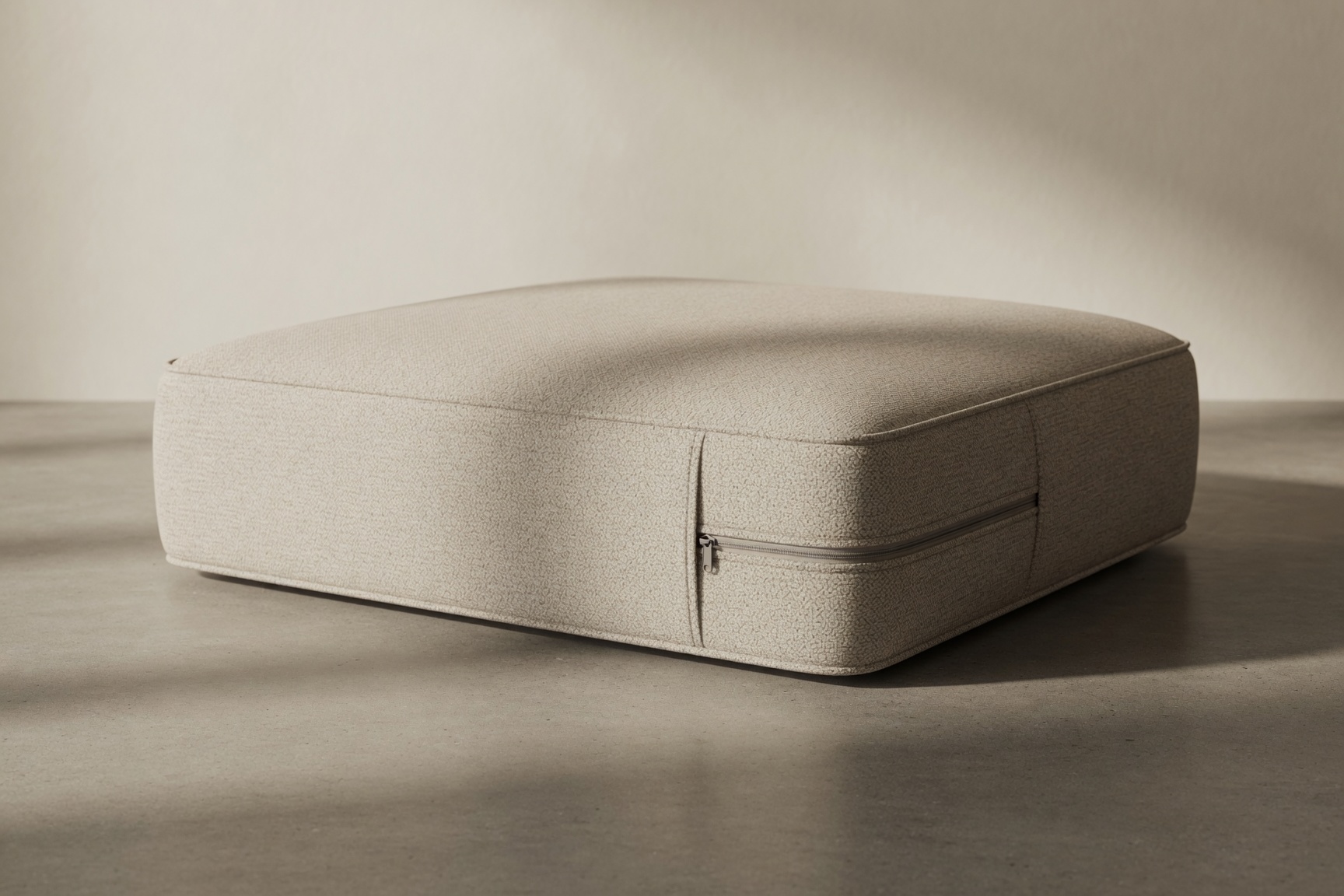 The Padfoundry mattress alone on warm concrete, three-quarter angle